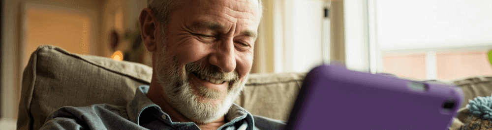 Man experiencing neck pain while using a tablet to access sports medicine and pain management options at Performance Pain and Sports Medicine.