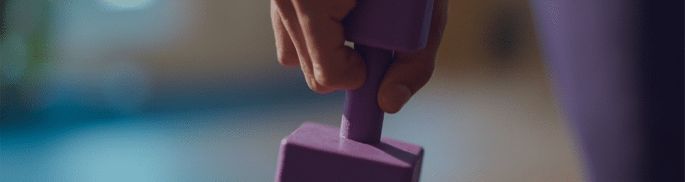 Dumbbell being held by a person during a sports medicine or physical therapy session.