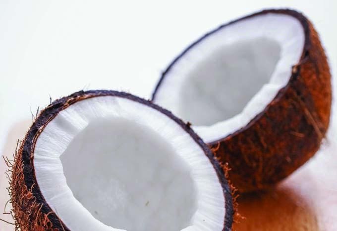Fresh coconut sliced open, highlighting its white flesh and textured brown shell for healthy nutrition and natural energy.